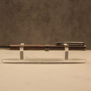one pen laying on a plastic stand, pen tip pointing left. It is made of two dark polished wooden segments, with gunmetal colored hardware. This is the type of pen that is twisted to expose or retract the pen tip, rather than clicking a button on the end