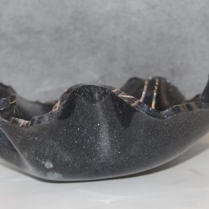 Dark purple sparkly bowl with wavy uneven walls that vary in heighth. Bowl is 11.5" wide, 3" deep, and 4"tall.