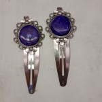 Decorative blossom hair clips in silver with blue/purple resin accents, combining floral elegance with functional hair styling accessories.