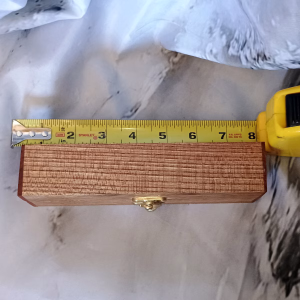Wooden box shown with tape for scale – compact form and practical charm