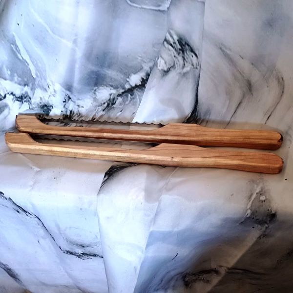 Hand-turned red maple bow knives with swirling grain and vibrant natural tones