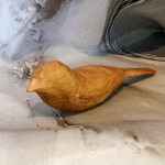 Smooth wooden bird worry stone with subtle wing carving in natural light wood, shaped for comfortable handling and mindful relaxation.