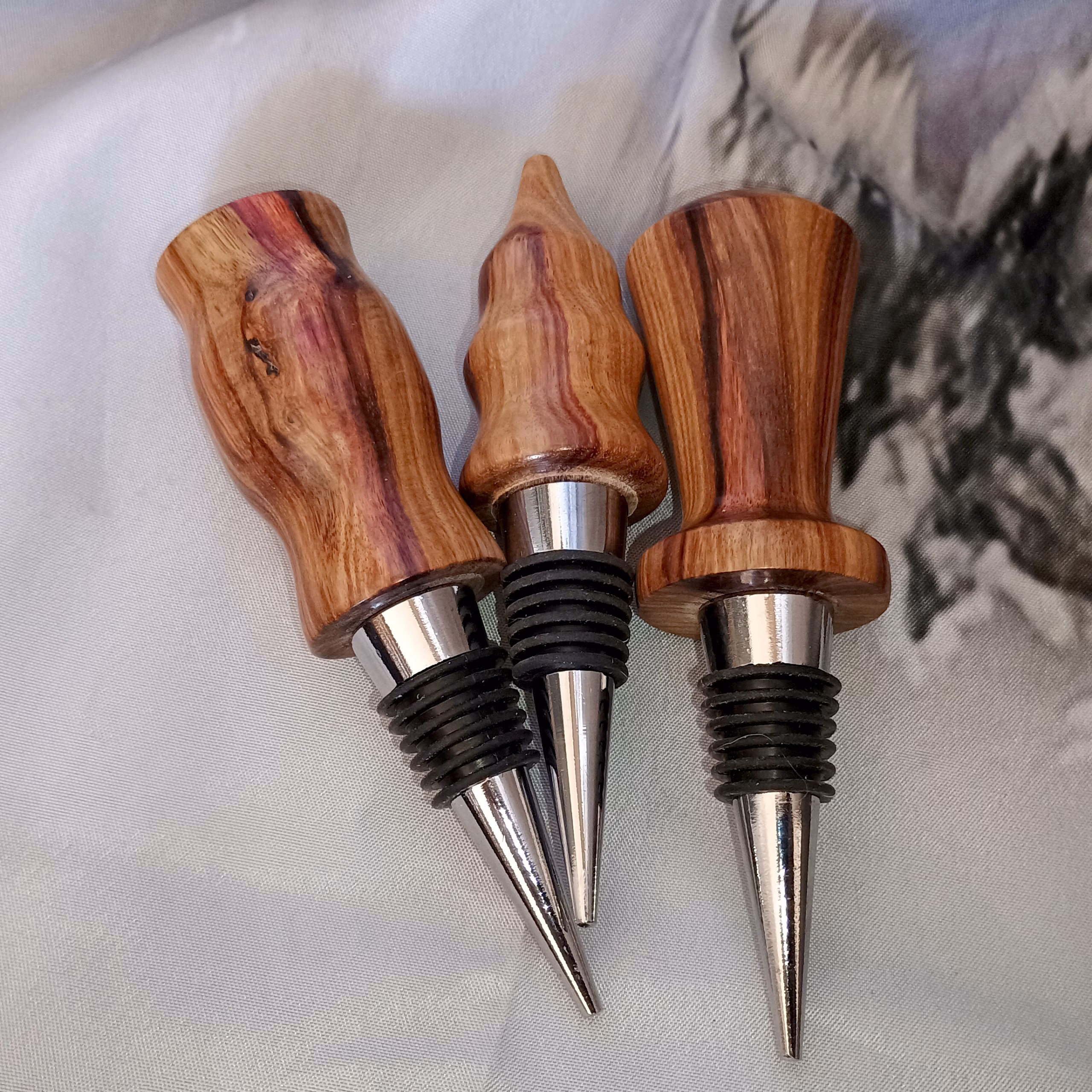 Handcrafted canary wood wine bottle stoppers with warm golden hardwood grain, artisan hand-turned bar accessories and elegant host(ess) gifts by Sarkanys Rising