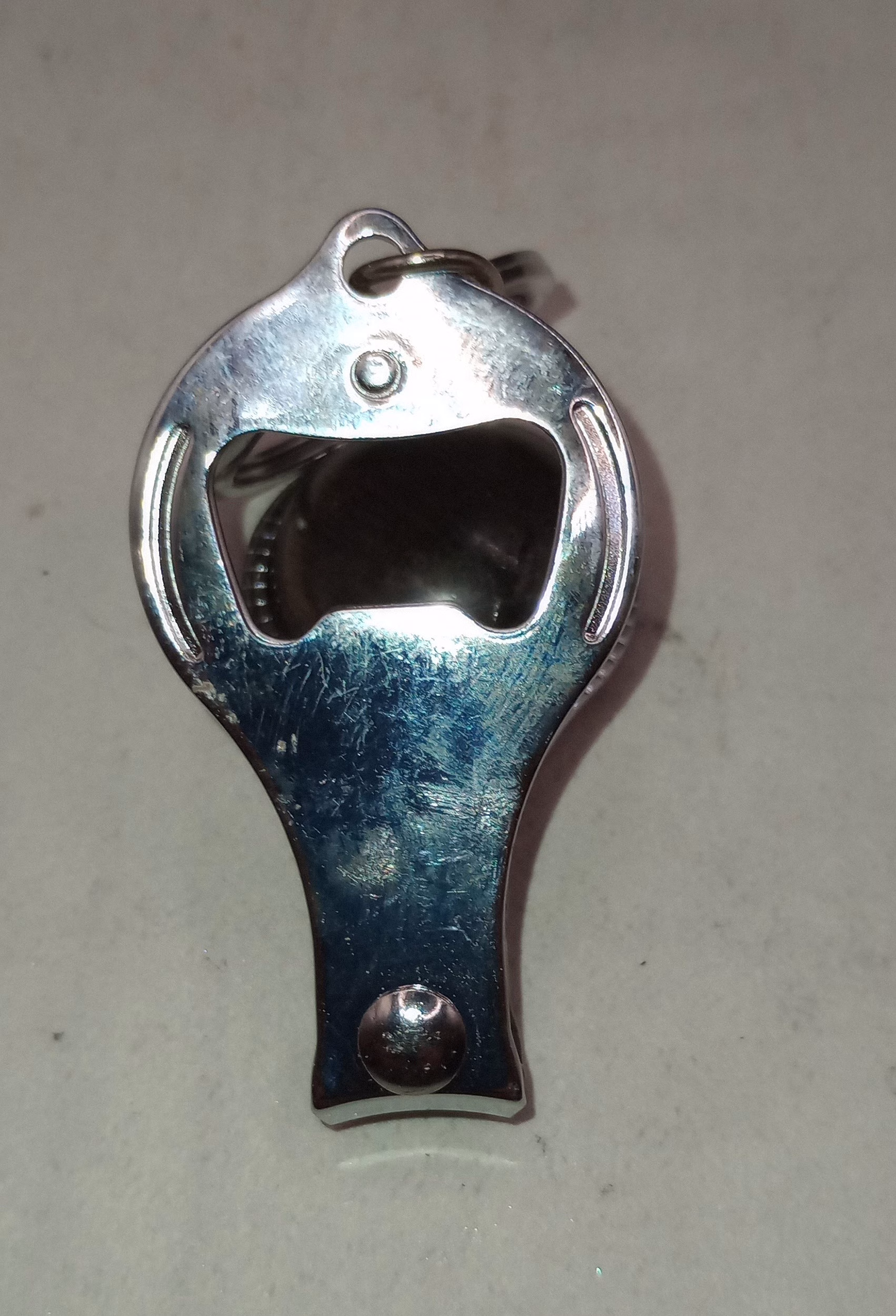 Stainless steel 3-in-1 keychain showing bottle opener opening, nail clipper, and key ring, handcrafted by Sarkanys Rising