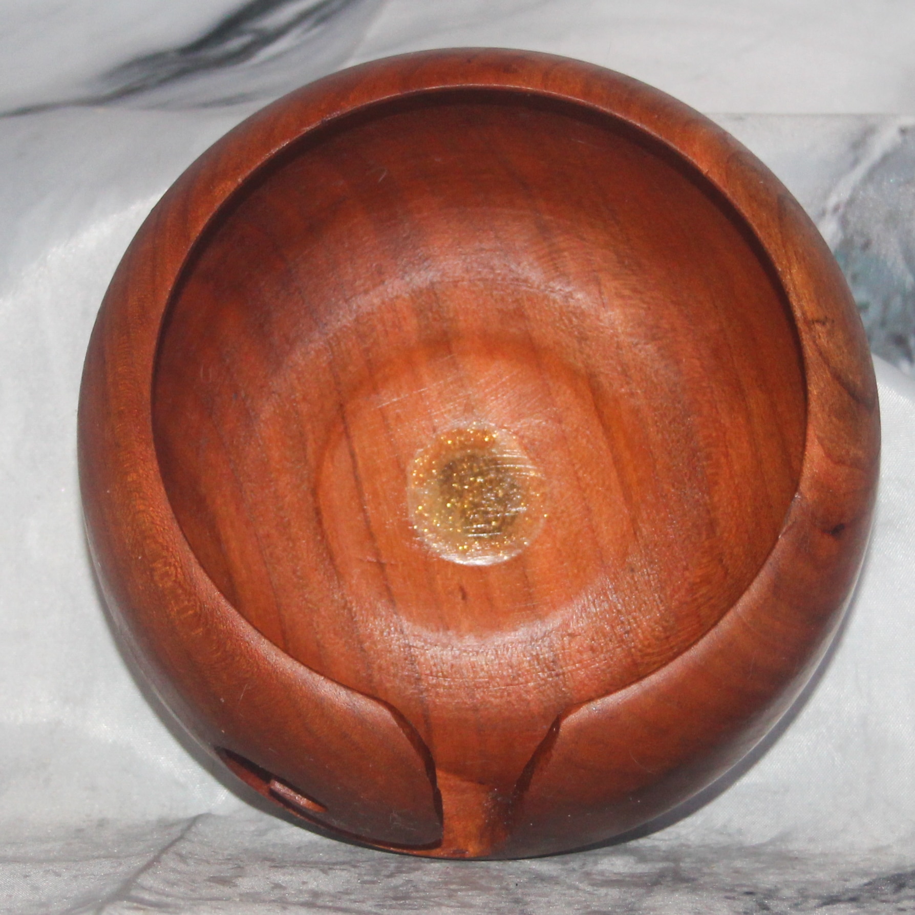 Interior view of a hand-turned cherry and walnut yarn bowl with glittering resin center inlay, cherry walnut hand-turned yarn bowl by Sarkanys Rising