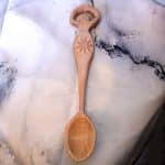 A hand carved spoon with the handle being a traditional Goddess as mother figure.