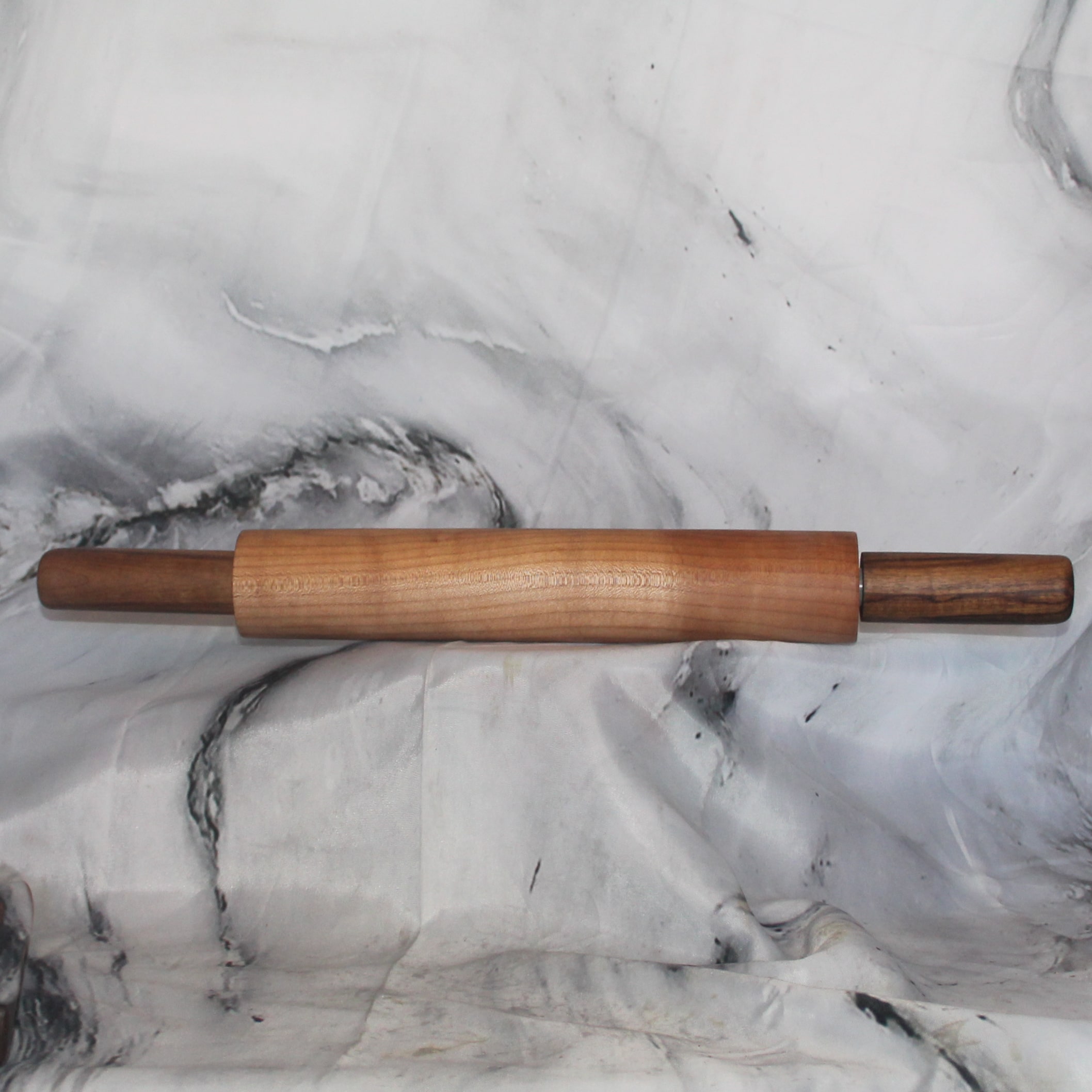 Maple & Walnut Rolling Pin: Side view of a hand-turned maple and walnut ball bearing rolling pin on a marble surface, maple walnut ball bearing rolling pin handcrafted by Sarkanys Rising