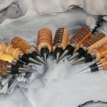Ten hand-turned bumpy lines bottle stoppers fanned out on marble background showing full collection of artisan scrap wood bar gifts by Sarkanys Rising Tucson