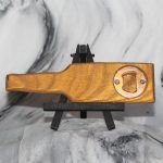 Reverse side of wood bottle shaped opener showing embedded stainless steel bottle opener mechanism set into handcrafted hardwood body